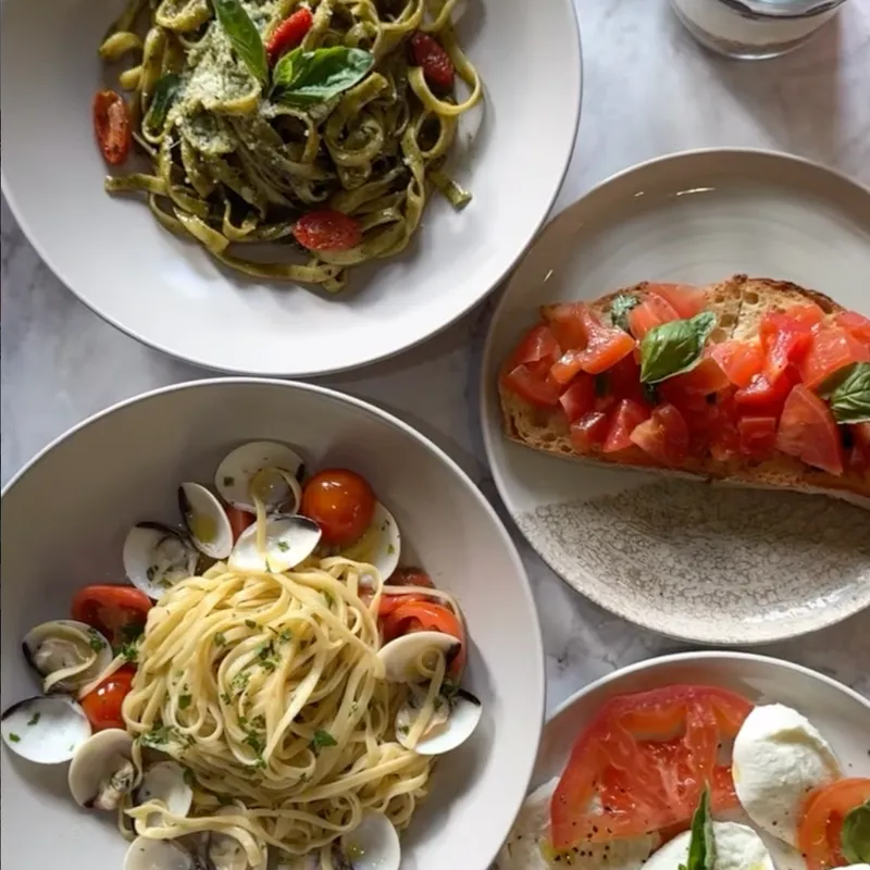 Fresh pasta spread — pesto tagliatelle, clam linguine, bruschetta and caprese